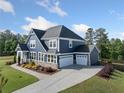 A side view showcasing the expansive driveway, three-car garage, and well-manicured lawn at 2111 Harmony Dr, Canton, GA 30115