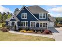 Charming two-story home with a blue exterior, well-manicured lawn, and stone accents at 2111 Harmony Dr, Canton, GA 30115