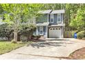 Charming two-story home with blue accents, attached garage, and mature trees surrounding the property at 2998 Kenville Ln, Decatur, GA 30034