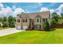 Beautiful brick home with a three car garage and a well manicured lawn at 981 Golden Meadows Ln, Loganville, GA 30052