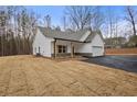 Beautiful new construction home featuring white siding, stone accents, and an attached two-car garage at 1687 Harmony Rd, Temple, GA 30153