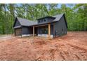 Contemporary gray home with wooden porch columns and attached garage on a spacious lot surrounded by trees at 1687 Harmony Rd, Temple, GA 30179
