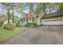 View of house, driveway and garage featuring traditional architecture with lovely landscaping and mature trees at 172 Forest Nw Ln, Marietta, GA 30064