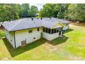 Expansive backyard featuring a screened-in porch, freshly cut green grass, and a white brick house at 5950 Central Church Rd, Douglasville, GA 30135