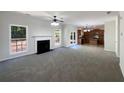 Spacious living room featuring a fireplace, large windows, and an open layout connecting to the kitchen area at 956 Buckhorn Bnd, Locust Grove, GA 30248