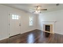 Bright living room with dark hardwood floors, a fireplace, and an adjacent front door at 1404 E Forrest Ave, Atlanta, GA 30344
