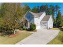 Side view of a lovely home with a three-car garage and a long driveway at 1438 Sutters Pond Nw Dr, Kennesaw, GA 30152