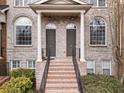 Close-up of brick townhome entrances with symmetrical design elements and lush green landscaping at 1123 Providence Pl, Decatur, GA 30033