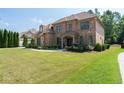 Well-maintained brick home with a spacious lawn and mature trees exudes classic elegance and charm at 2365 Barrington Trace Sw Cir, Atlanta, GA 30331