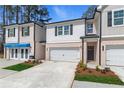 Charming townhome exterior featuring a two-car garage and manicured landscaping at 421 Brooch Way, Stockbridge, GA 30281