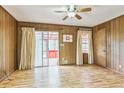 Living room featuring wood paneled walls, and sliding glass doors leading to screened in patio at 5295 Woodland Dr, Lake City, GA 30260