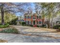 Charming two-story brick home with a circular driveway and lush landscaping at 55 Asheworth Ct, Atlanta, GA 30327