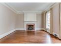 Cozy living room with hardwood floors, fireplace, and large window with natural light at 55 Asheworth Ct, Atlanta, GA 30327