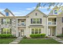 Beautiful townhome with stone and brick facade, upper balconies, and a well-maintained lawn at 7691 Cabrini Pl, Fairburn, GA 30213