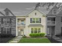 Striking townhome showcasing stone and brick facade, upper balconies, and a lush green lawn at 7691 Cabrini Pl, Fairburn, GA 30213