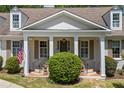 Inviting front porch features columns, brick steps, an American flag, and manicured greenery at 998 Ferncliff Ne Rd, Atlanta, GA 30324