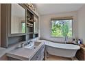 Relaxing bathroom with a freestanding tub, gray vanity with a sink, and a window at 2675 Dacula Ridge Dr, Dacula, GA 30019