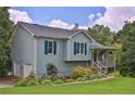 Charming home with light blue siding, front porch, lush lawn, and beautiful landscaping at 2675 Dacula Ridge Dr, Dacula, GA 30019