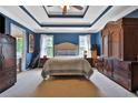 Spacious main bedroom featuring tray ceilings, blue walls, and a cozy queen bed at 2675 Dacula Ridge Dr, Dacula, GA 30019