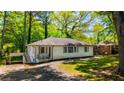 Inviting single-story home with a white exterior, a covered carport, and a well-maintained front yard with mature trees at 754 Pinehill Se Dr, Smyrna, GA 30080