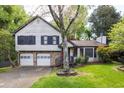 Charming two-story home featuring a stone facade, red door, two-car garage and a well-manicured lawn and mature trees at 1763 Hearthstone Cir, Lawrenceville, GA 30043