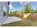 Large, grassy backyard with a concrete patio and wooden fence, perfect for outdoor activities at 2316 Hastings Manor Ln, Hampton, GA 30228