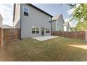 Spacious backyard with a well-maintained lawn, privacy fence, and concrete patio at 2316 Hastings Manor Ln, Hampton, GA 30228