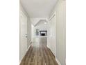 Long hallway with wood floors leading to a living area with a fireplace and vaulted ceilings at 4805 Diggers Way, Sugar Hill, GA 30518