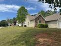 Well-maintained home with a two-car garage, stone accents, and a green lawn in a residential neighborhood at 10111 Commons Way, Jonesboro, GA 30238