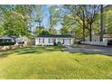 Cozy single-story home surrounded by mature trees, featuring a well-kept lawn and driveway at 5573 Singleton Rd, Norcross, GA 30093