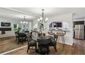 Elegant dining area open to the kitchen with a mirrored wall and stylish lighting fixture at 908 Hollyfax Cir, Sandy Springs, GA 30328