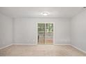 Finished basement area with neutral carpet, a sliding glass door to the outside, and ample natural light at 1728 Devon Sw Dr, Atlanta, GA 30311