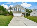 Two-story home with an attached two-car garage, long driveway and grassy front lawn at 74 Macland Mill Ln, Dallas, GA 30157
