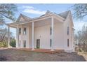 Two-story home featuring a white exterior, covered porch, and classic architectural details at 119 E Johnson St, Temple, GA 30179