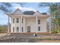 Charming white two-story home with a covered front porch supported by elegant columns at 119 E Johnson St, Temple, GA 30179