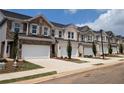 Several townhouses with brick and siding, attached garages, and landscaping define this picturesque community at 877 Pensive Run, Dacula, GA 30019
