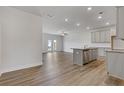 Open concept kitchen flows into the living area, featuring stainless steel appliances and laminate flooring at 877 Pensive Run, Dacula, GA 30019