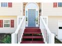 Close-up of the front door entrance, with white railings and brick steps leading up at 140 Maplewood Dr, Temple, GA 30179
