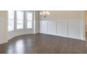 Bright dining room featuring hardwood floors, wainscoting, and ample natural light at 1821 Silver Crest Way, Hoschton, GA 30548