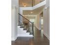 Elegant staircase with dark wood railings, leading to an open-concept living area at 1821 Silver Crest Way, Hoschton, GA 30548