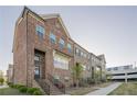Brick townhomes showing balconies, sidewalks, and manicured landscaping at 3877 Via Cima Ln, Suwanee, GA 30024
