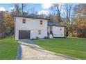 Beautifully renovated house with a well-maintained lawn and a driveway leading to the garage at 9148 Homewood Dr, Riverdale, GA 30274