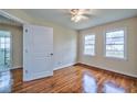 Bright bedroom with hardwood floors, a ceiling fan, and a door leading to an updated bathroom at 933 Dell Se Ave, Smyrna, GA 30080