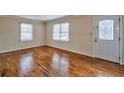 Bright living room showcasing gleaming hardwood floors, two windows, and a stylish front door at 933 Dell Se Ave, Smyrna, GA 30080