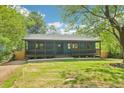 Inviting home with a covered porch, lush green lawn, and mature trees providing shade at 1596 Pontiac Se Pl, Atlanta, GA 30315