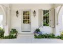 Welcoming home entrance with stylish lanterns, shutters and lush landscaping with blue flowers at 3489 Knollwood Nw Dr, Atlanta, GA 30305