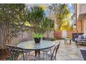 Relaxing outdoor patio area with a glass-top table, wrought iron furniture, and mature trees at 3707 Peachtree Ne Rd # 8, Atlanta, GA 30319
