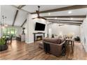 Open-concept living room with exposed beams, a fireplace, and wood floors at 230 Summerfield Dr, Alpharetta, GA 30022