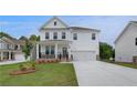 Inviting two-story home featuring a covered front porch, two-car garage, and a green lawn at 540 Teversham Dr, Mcdonough, GA 30253