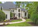 Beautiful custom home with manicured lawn and stone walkway leading to the front entrance at 960 Tiverton Ln, Alpharetta, GA 30022